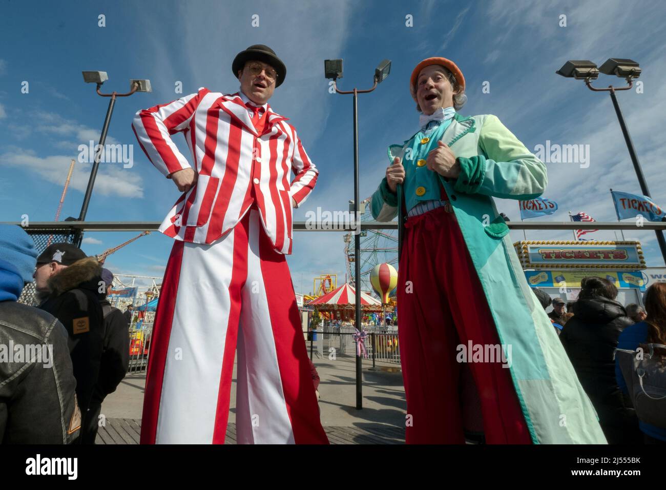 Männer auf Stelzen bei der Saisoneröffnung für Deno's Wonder Wheel Amusement Park auf der Promenade in Coney Island, Brooklyn, New York City, Stockfoto
