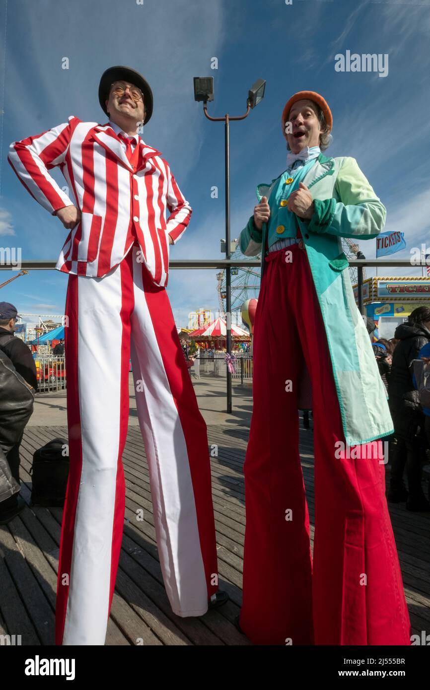 Männer auf Stelzen bei der Saisoneröffnung für Deno's Wonder Wheel Amusement Park auf der Promenade in Coney Island, Brooklyn, New York City, Stockfoto