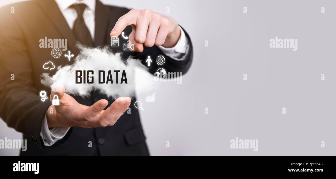 Geschäftsmann hält die Inschrift , Wort BIG DATA . Vorhängeschloss, Gehirn, Mann, Planet, Graph, Lupe, Zahnräder, Symbol für Cloud, Grid, Dokument, Brief, Telefon Stockfoto