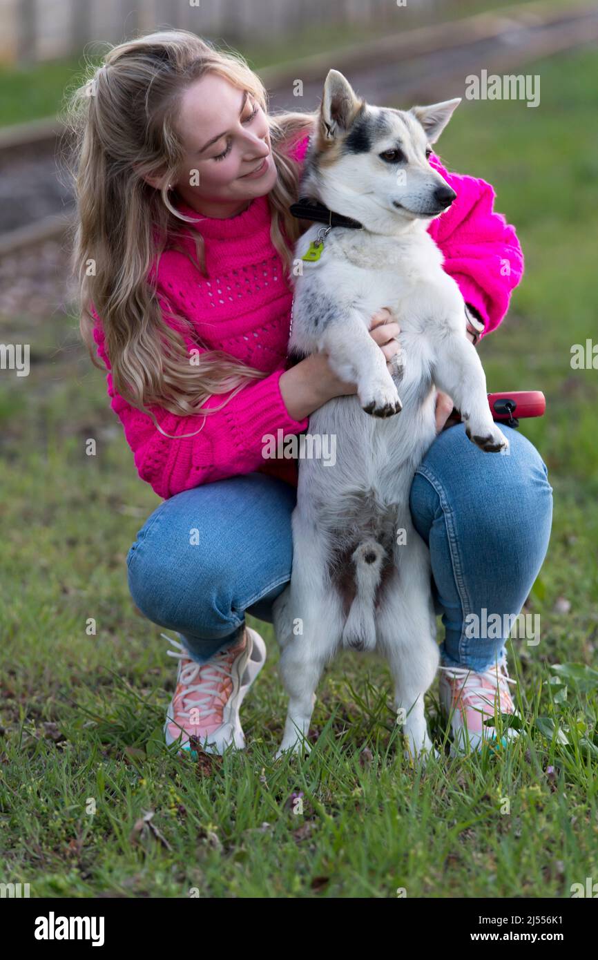 Blonde niedliche Mädchen mit ihrem Hund im Freien Stockfoto