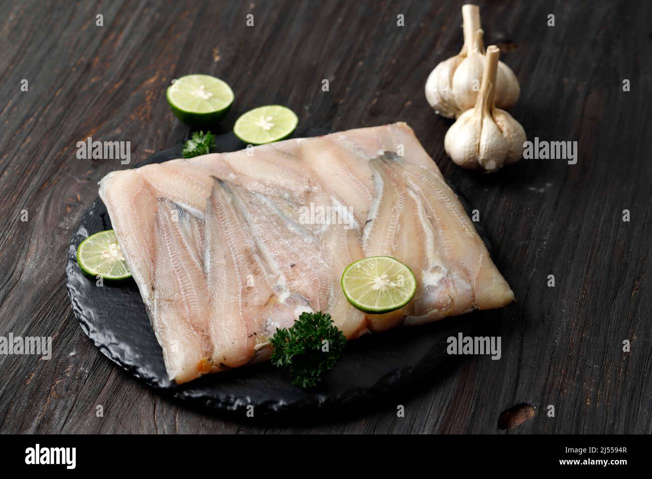 Ausgewählter Fokus Frozen Wels Filet auf schwarzem Holztisch Stockfoto