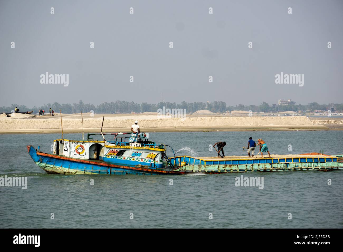 Mit Sand beladene Boote treiben entlang des Flusses.Blick auf den Fluss Padma in Bangladesch. Stockfoto