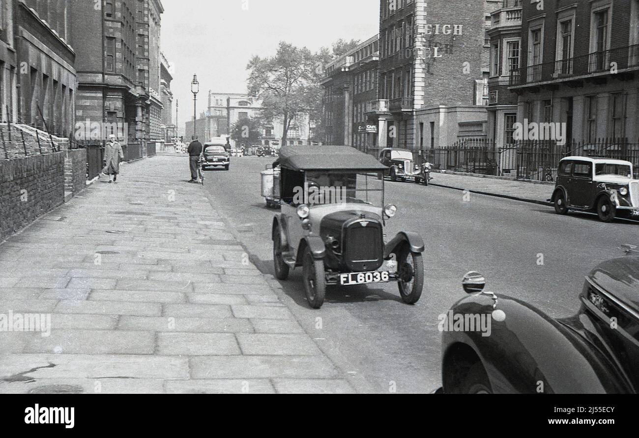 1960, historisch, ein Austin 7 Auto aus dem Jahr 1920s - auch bekannt als Austin Chummy - parkte zusammen mit anderen Autos auf einer Straße in Endsleigh Gardens, Bloomsbury, London, England, UK. Das Endsleigh Hotel befindet sich auf der rechten Seite die Straße hinauf, das ursprünglich die Südseite des Euston Square war, aber 1879 umgemustzt wurde. Der Austin 7, der von 1922 bis 1939 in Großbritannien produziert wurde, war ein kleines Auto, ein „Baby Austin“ mit begrenztem Platz auf der Rückseite, sodass alle Insassen sehr nah beieinander waren, also „chummy“. Stockfoto