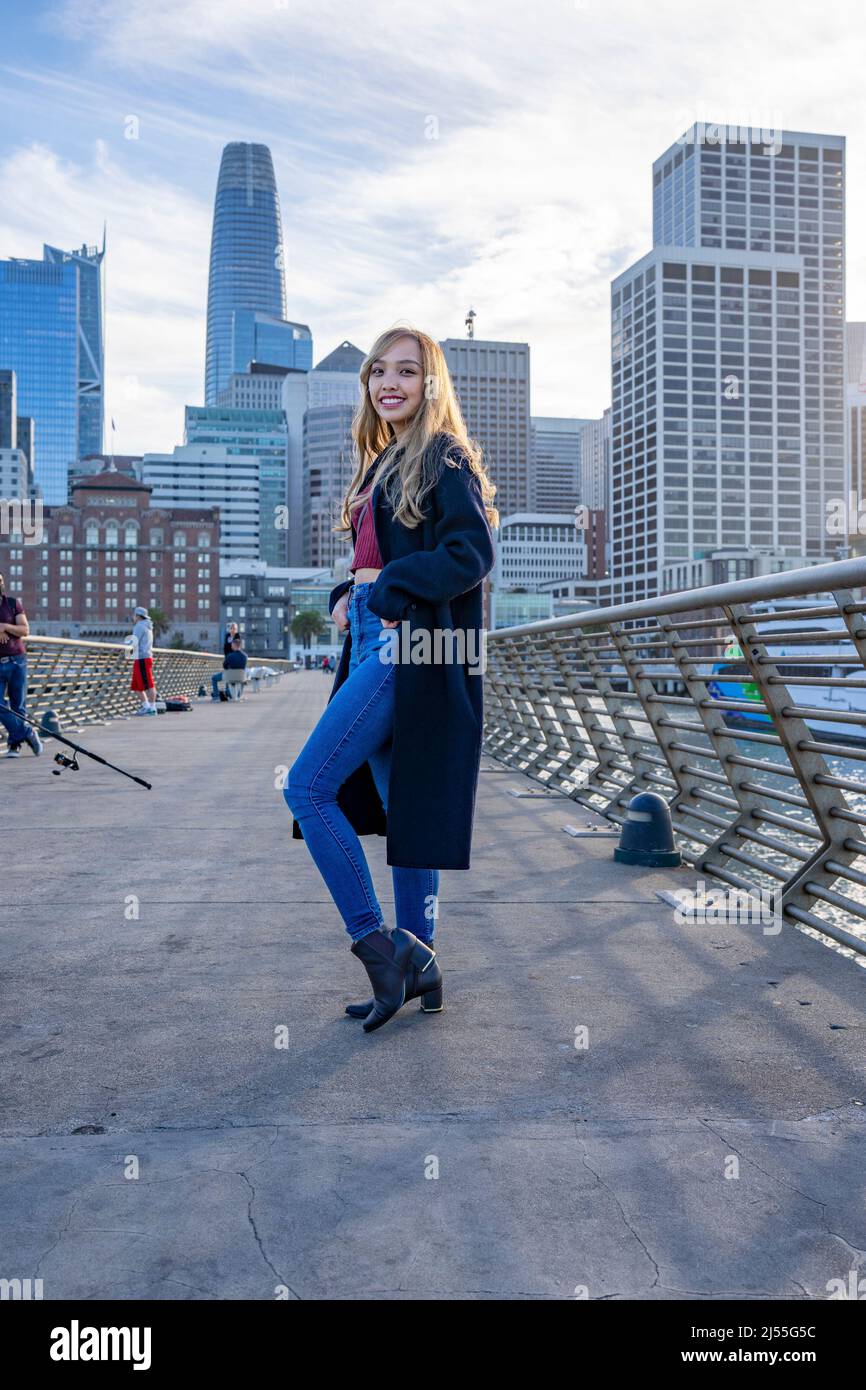 Junge Frau am Pier mit der Skyline von San Francisco im Hintergrund | Lifestyle Local Travel Stockfoto