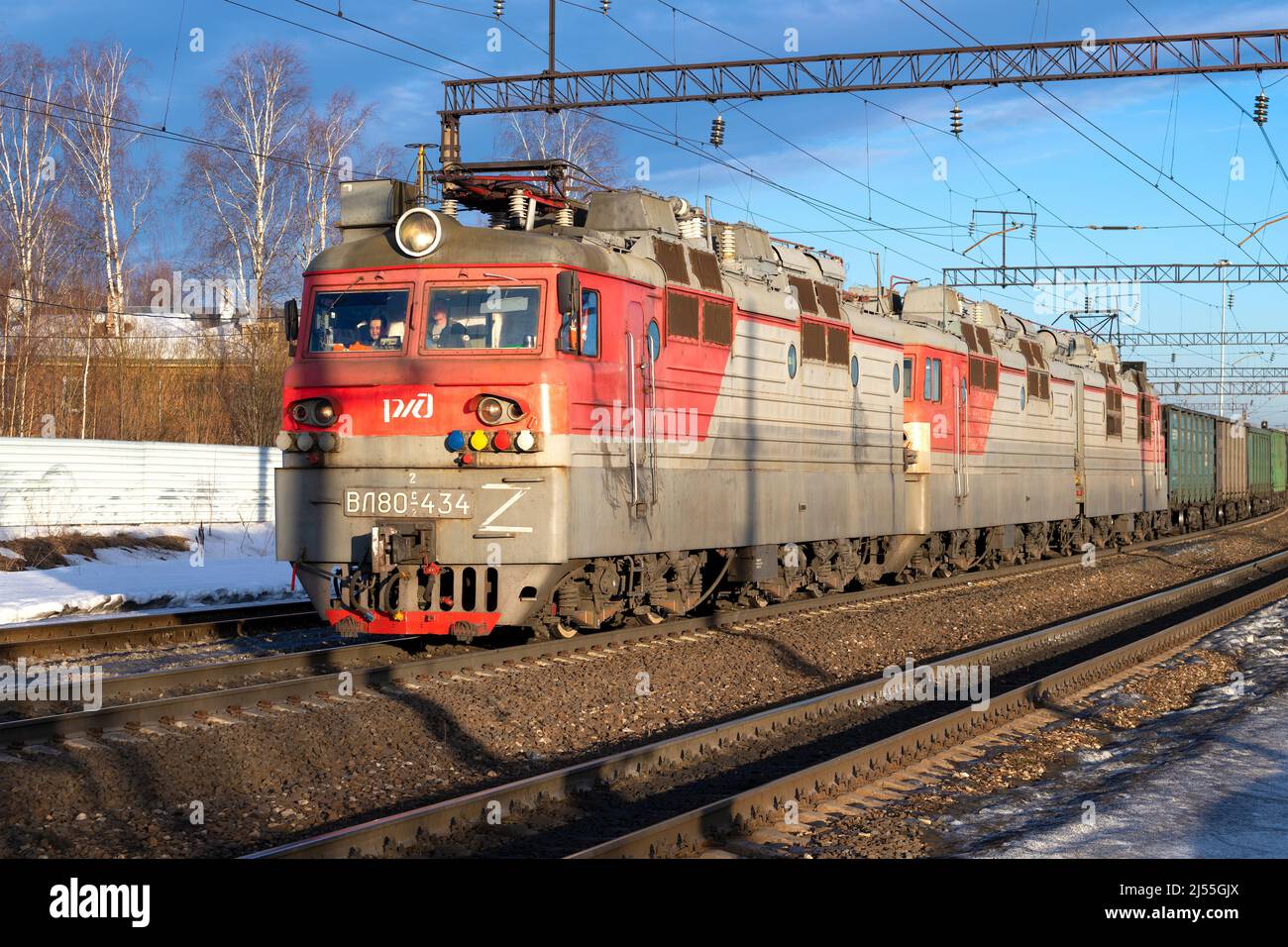 SHARYA, RUSSLAND - 19. MÄRZ 2022: Elektrische Lokomotive VL-80s in dreistufiger Ausführung mit Nahaufnahme eines Güterzugs an einem sonnigen Märztag Stockfoto