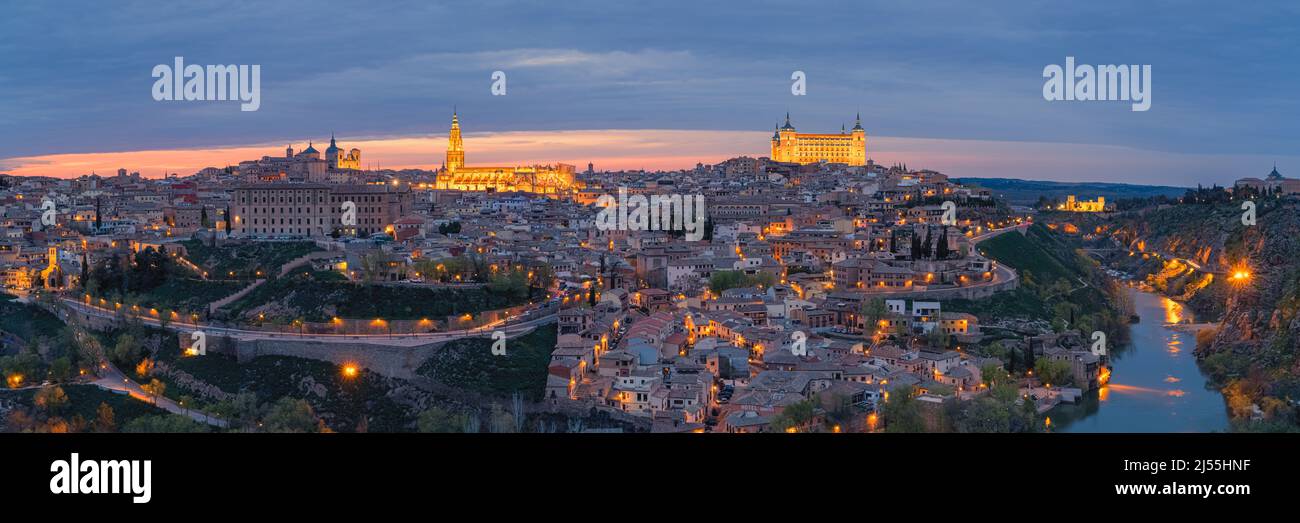 Ein breites Panoramabild von einem Abend in Toledeo mit Blick auf die Kathedrale (Catedral de Santa María de Toledo) und den Alcazar von Toledo. Stockfoto