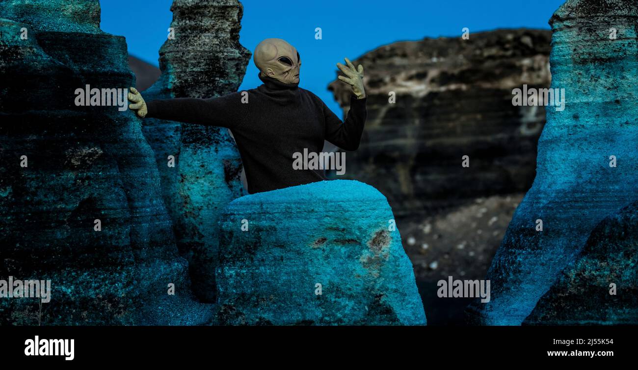 Blaue Nacht und Alien ufo Maske zwischen Felsen. Konzept der Aliens unter uns. Weltraum entdecken und Zukunft mit außerirdischem Leben. Horror gruselig Konzept i Stockfoto