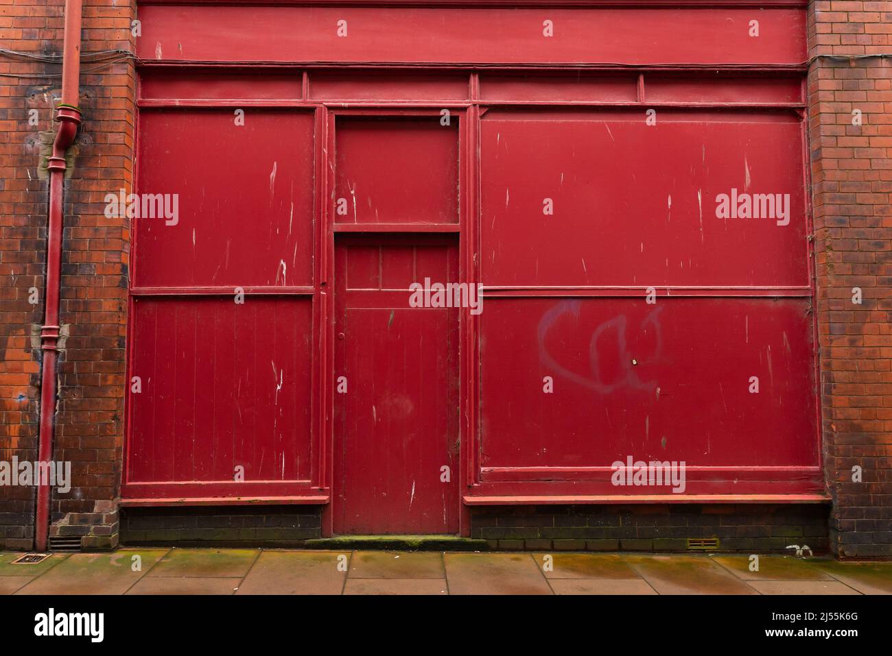 Rote Industrietüren auf einem alten Backsteingebäude in der englischen Stadt. Carlisle, England. Stockfoto