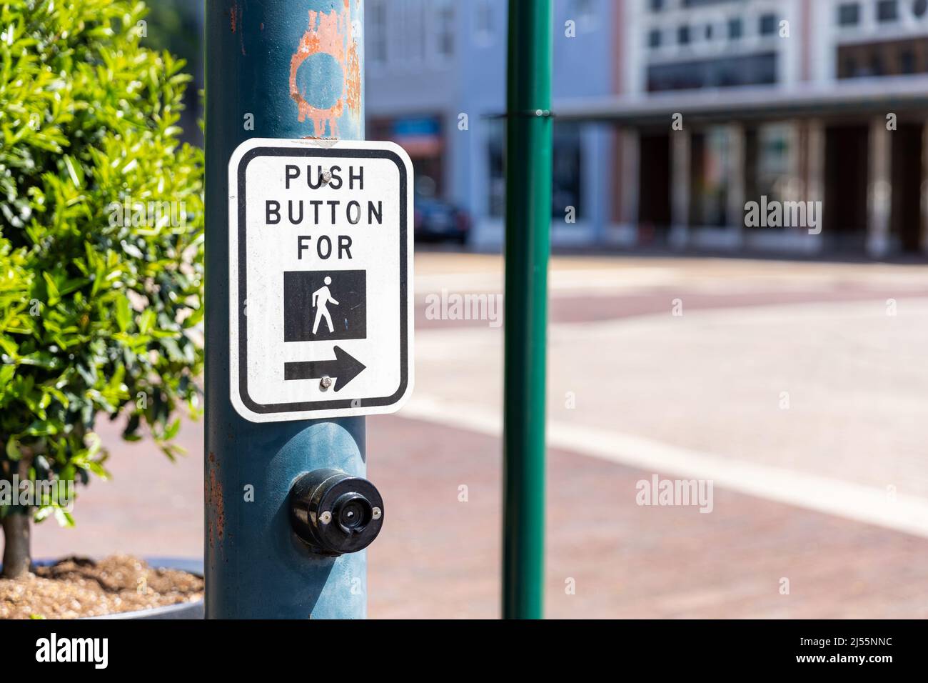 Überqueren Sie das Fußgängerschild und die Schaltfläche, um eine Kreuzung in der Innenstadt zu überqueren Stockfoto