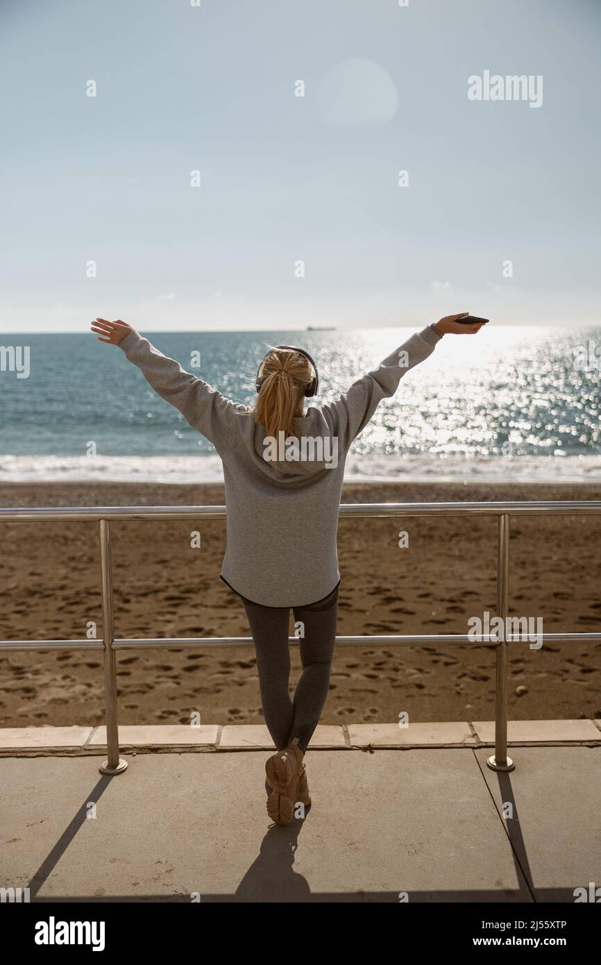 Junge Frau, die sich nach dem Training an der Küste entspannt Stockfoto