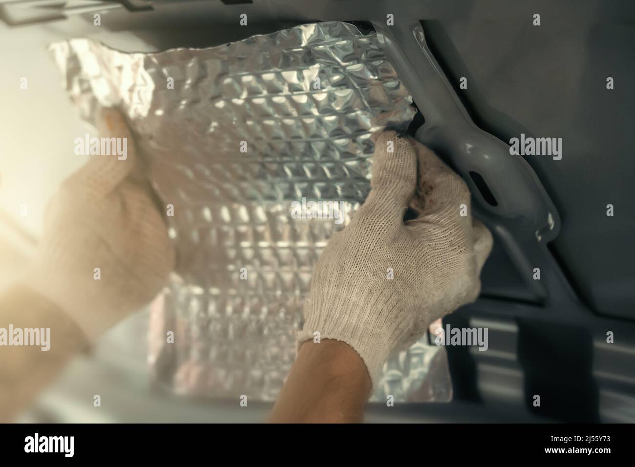 Arbeiter installieren spezielle akustische und vibrationsdämpfende Material für Schalldämmung. Schallisolierung, automatische Abstimmung. Stockfoto