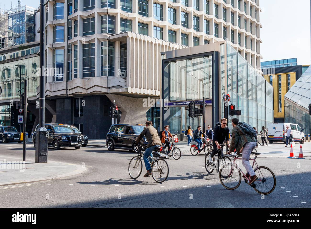 Radfahrer und Taxis an der Kreuzung Tottenham Court Road und Oxford Street, London, Großbritannien Stockfoto