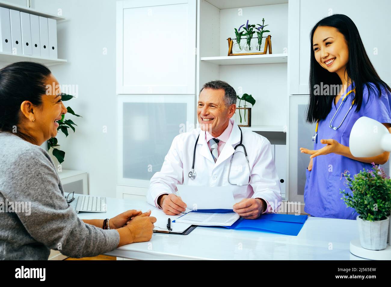 Lächelnde Ärztin, Krankenschwester und Patientin in der Krankenhausindustrie Stockfoto
