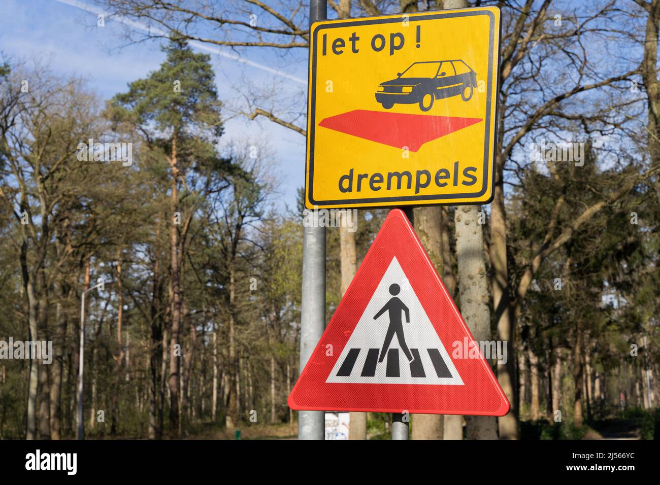 Warnschild für Straßenbump (Drempels) auf gelbem quadratischen Hintergrund über einem Dreieck-Fußgängerübergangsschild in den Niederlanden Stockfoto