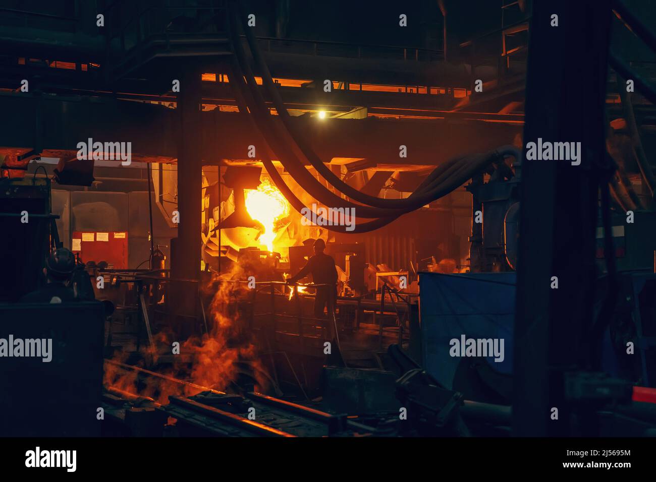 Eisenguss-Prozess in der metallurgischen Fabrik. Geschmolzenes Metall Gießen aus Schöpfkelle in der Werkstatt. Stockfoto