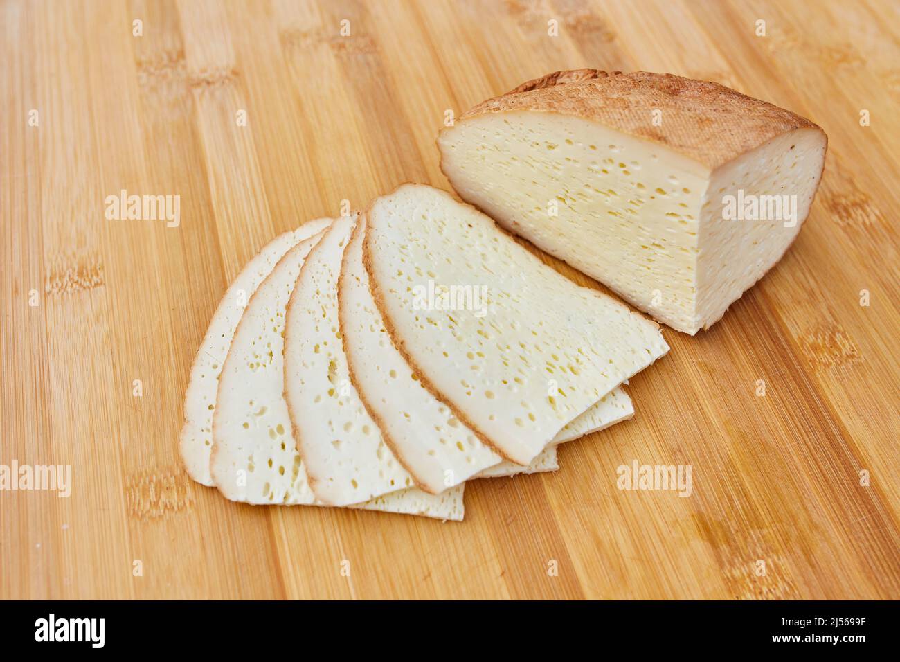 Hausgemachter geräucherter Käse auf einem Holzbrett geschnitten Stockfoto