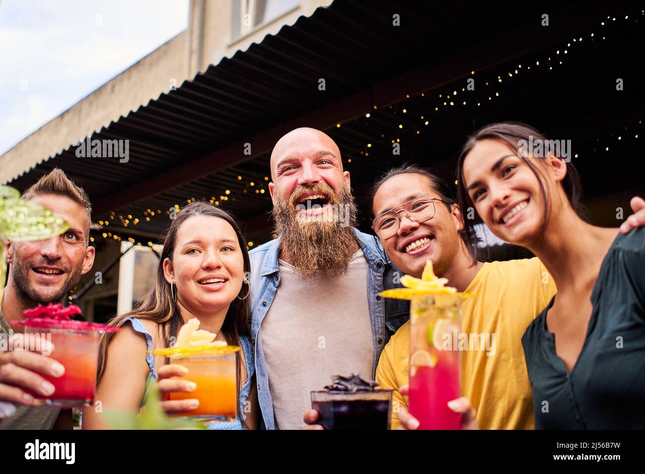 Selfie-Gruppe von Menschen jubelt und hat Spaß. Multirassische glückliche Freunde trinken und toasten Cocktails in der Brauerei-Bar, die zusammen Fotos machen Stockfoto