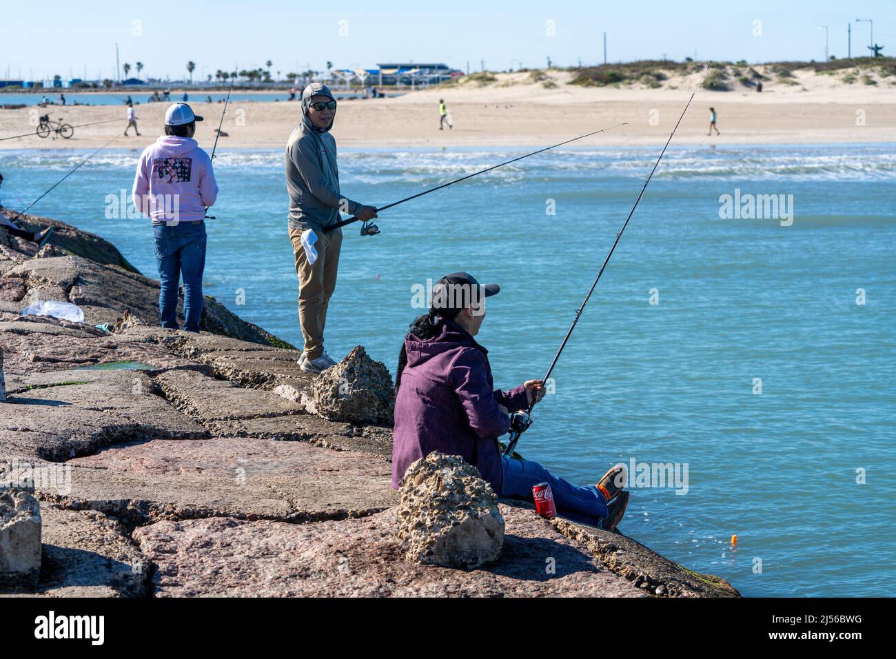 Salzwasserfischer auf der Anlegestelle des Schiffskanals des Brazos Santiago Pass auf South Padre Island, Texas. Stockfoto