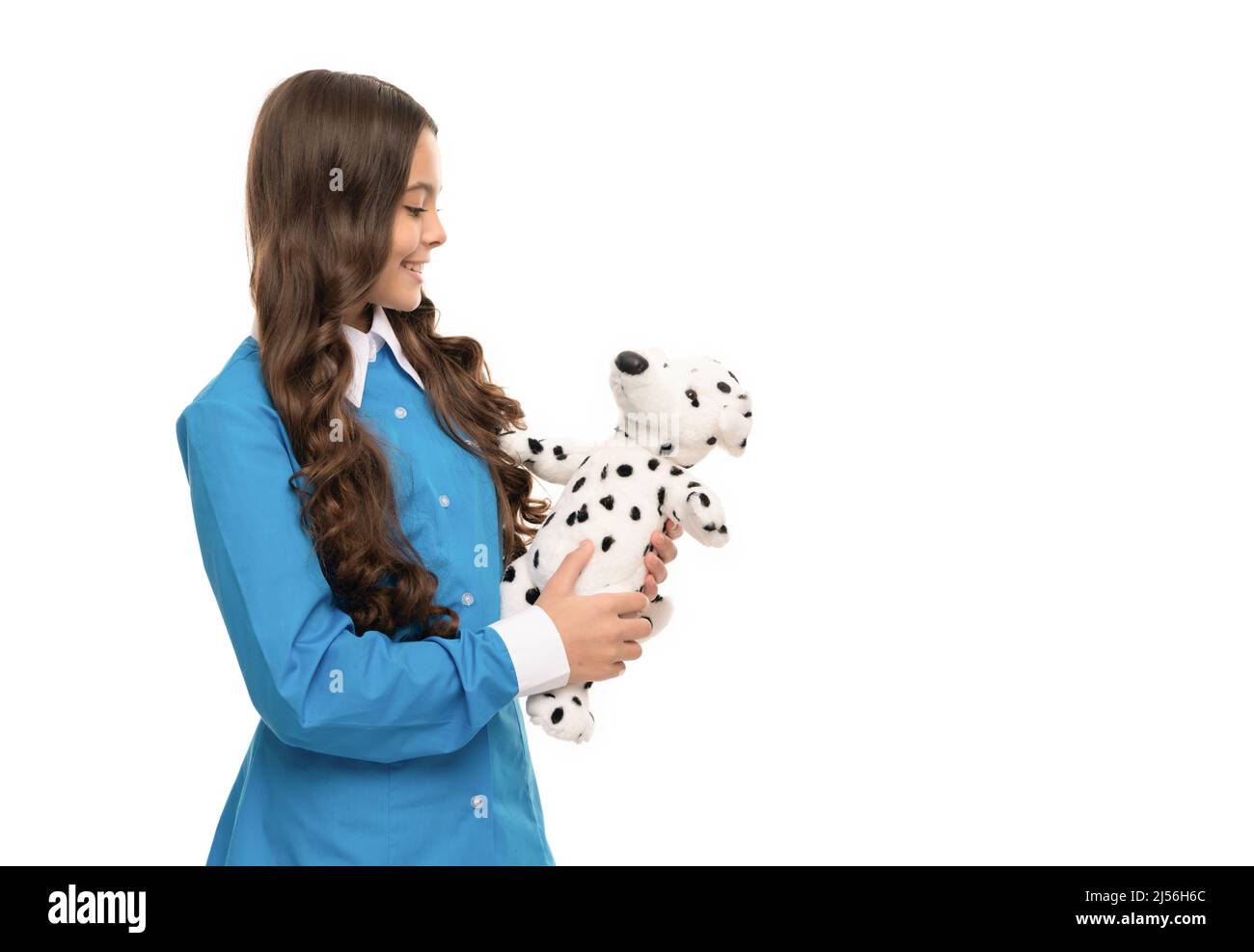 Spielen mit Hund Spielzeug. Hübsches Aussehen des jungen Mädchens. Porträt des glücklichen Kindes isolieren auf weiß. Stockfoto