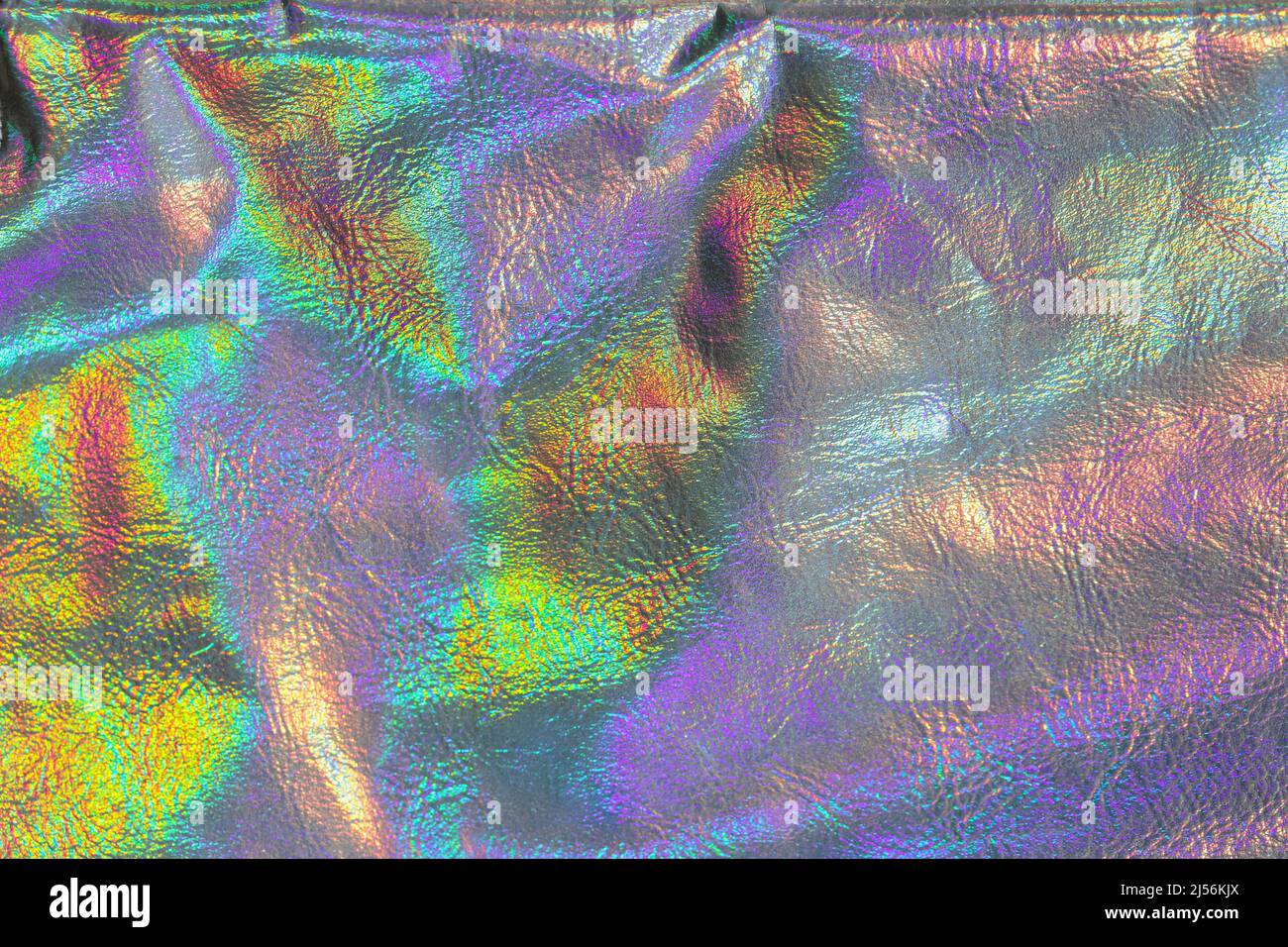 Holographisches Material aus Metall. Holografischer Hintergrund. Tapete in silbernen, violetten Farben. Textur mit schillernden Wellen und Falten. Abstrakt trendy Stockfoto