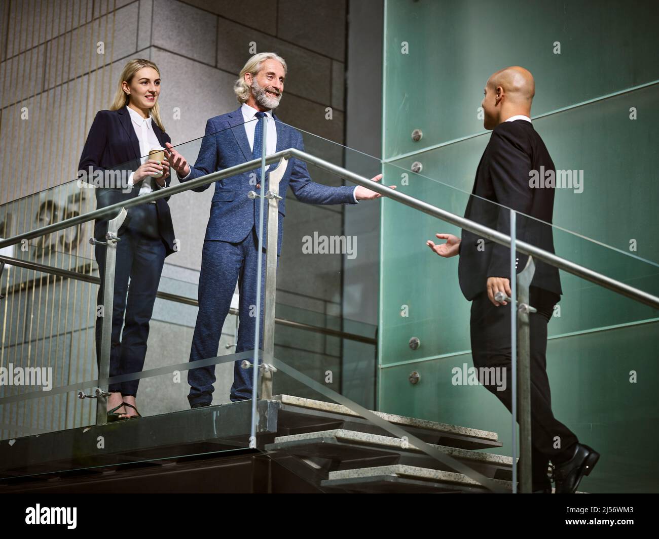 der kaukasische Geschäftsführer begrüßt einen Gast bei Latino in einem modernen Bürogebäude Stockfoto