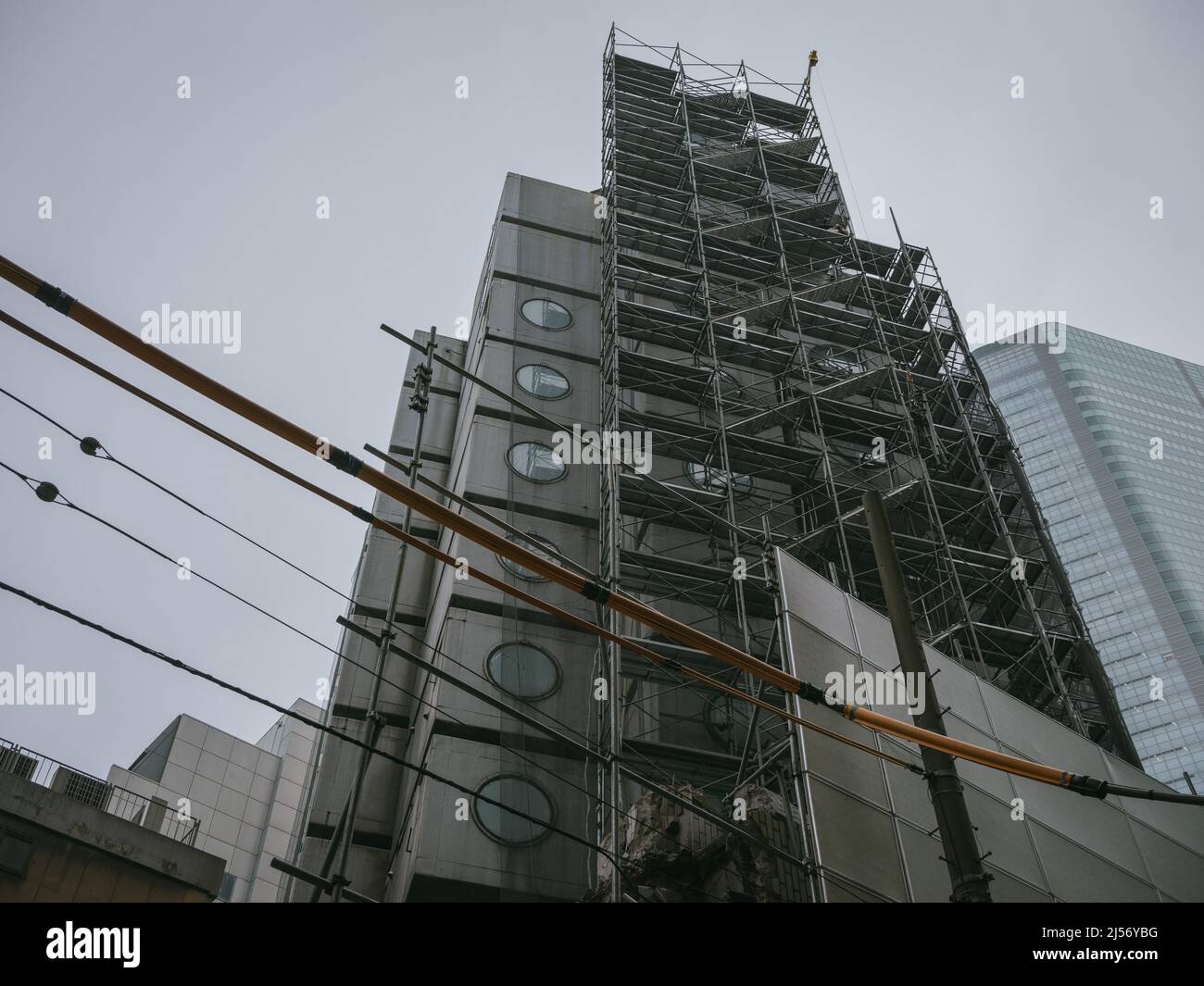 Bauarbeiter bauen Gerüste ein, während die Arbeiten beginnen, den Wahrzeichen Nakagin Capsule Tower abzureißen, ein Wohn- und Bürogebäude, das Anfang 1970s gebaut wurde und ein Beispiel für Japans Architekturdesign-Bewegung der Nachkriegszeit, bekannt als Metabolism, am 20. April 2022 im Tokioter Stadtteil Ginza ist.20. April 2022 Quelle: Nicolas Datiche/AFLO/Alamy Live News Stockfoto
