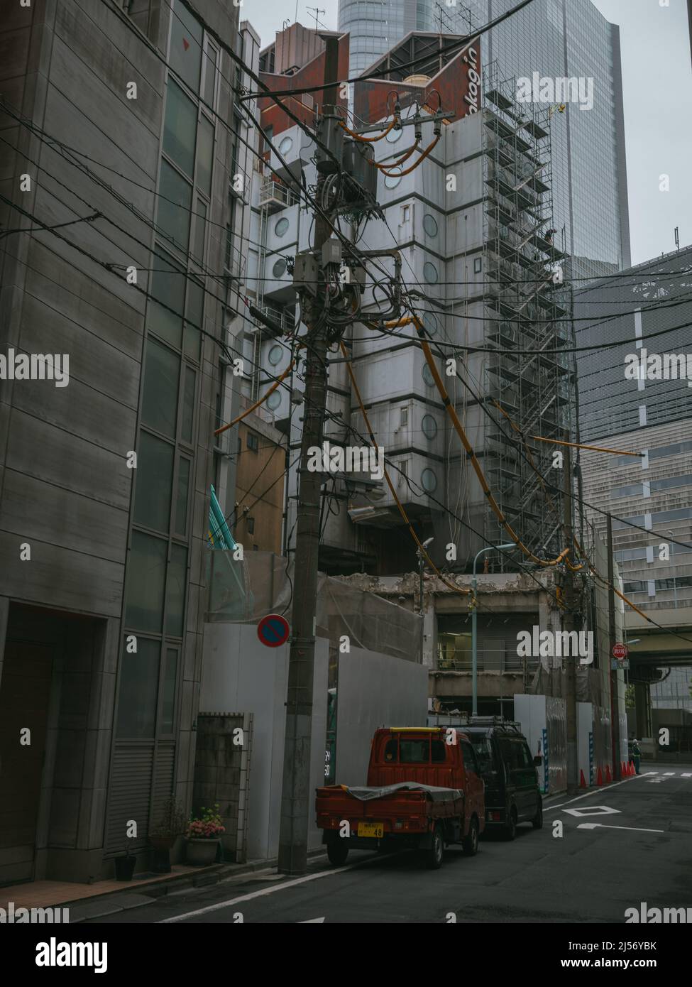 Bauarbeiter bauen Gerüste ein, während die Arbeiten beginnen, den Wahrzeichen Nakagin Capsule Tower abzureißen, ein Wohn- und Bürogebäude, das Anfang 1970s gebaut wurde und ein Beispiel für Japans Architekturdesign-Bewegung der Nachkriegszeit, bekannt als Metabolism, am 20. April 2022 im Tokioter Stadtteil Ginza ist.20. April 2022 Quelle: Nicolas Datiche/AFLO/Alamy Live News Stockfoto