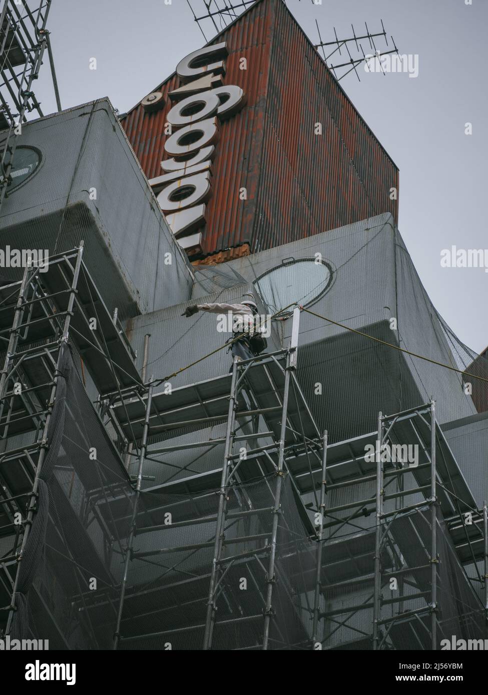 Bauarbeiter bauen Gerüste ein, während die Arbeiten beginnen, den Wahrzeichen Nakagin Capsule Tower abzureißen, ein Wohn- und Bürogebäude, das Anfang 1970s gebaut wurde und ein Beispiel für Japans Architekturdesign-Bewegung der Nachkriegszeit, bekannt als Metabolism, am 20. April 2022 im Tokioter Stadtteil Ginza ist.20. April 2022 Quelle: Nicolas Datiche/AFLO/Alamy Live News Stockfoto