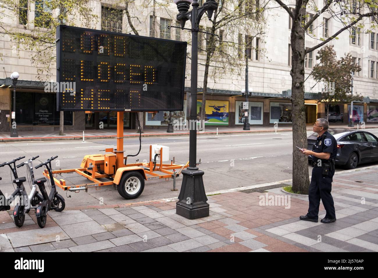 Seattle, USA. 20. April 2022. Spät am Tag Seattle Polizei Überprüfung einer Straße geschlossen voraus Zeichen auf 4. und Pine in Westlake. Präsident Biden soll am Donnerstag die Stadt zu einer Spendenaktion der DNC besuchen, gefolgt von zwei Veranstaltungen am Erdtag, um den Klimawandel zu diskutieren. Quelle: James Anderson/Alamy Live News Stockfoto