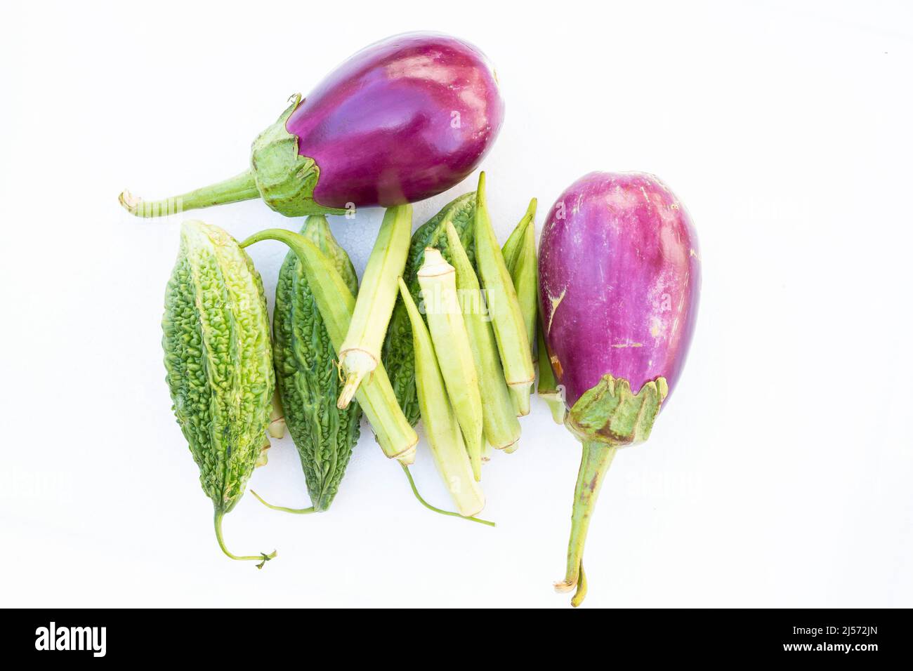 Bitterer Kürbis, Okra und Auberginen auf weißem Hintergrund. Stockfoto