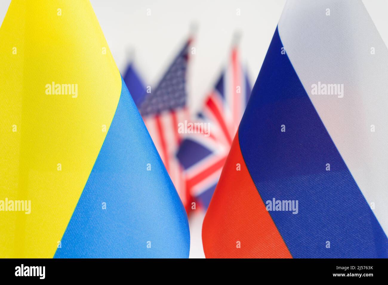 Staatsflagge von Russland und der Ukraine. Flaggen in Großbritannien und den USA auf dem Hintergrund. Russischer ukrainischer Kriegskonflikt Stockfoto