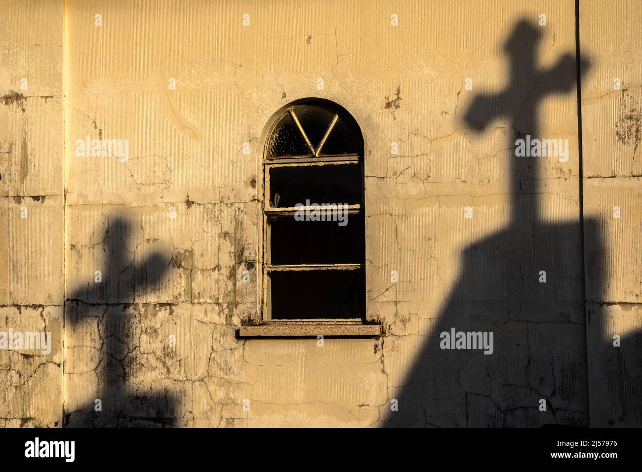 Schatten von Kreuzen an der Wand einer alten Kapelle auf einem Friedhof in Brasilien Stockfoto