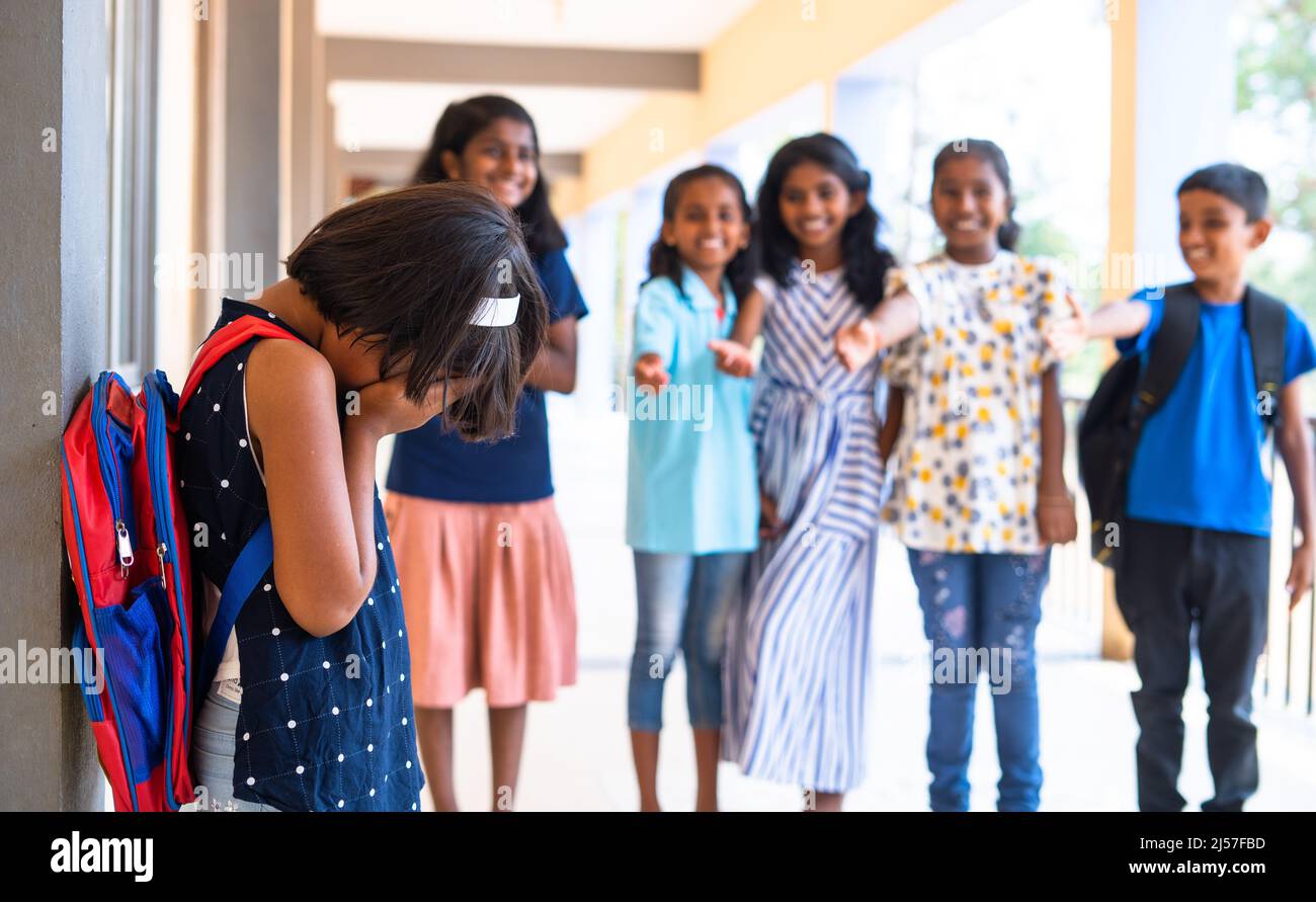 Mädchen Kind wird von einer Gruppe von Kindern im Schulkorridor schikaniert - Konzept der Ablehnung, unschuldig und Opfer Stockfoto