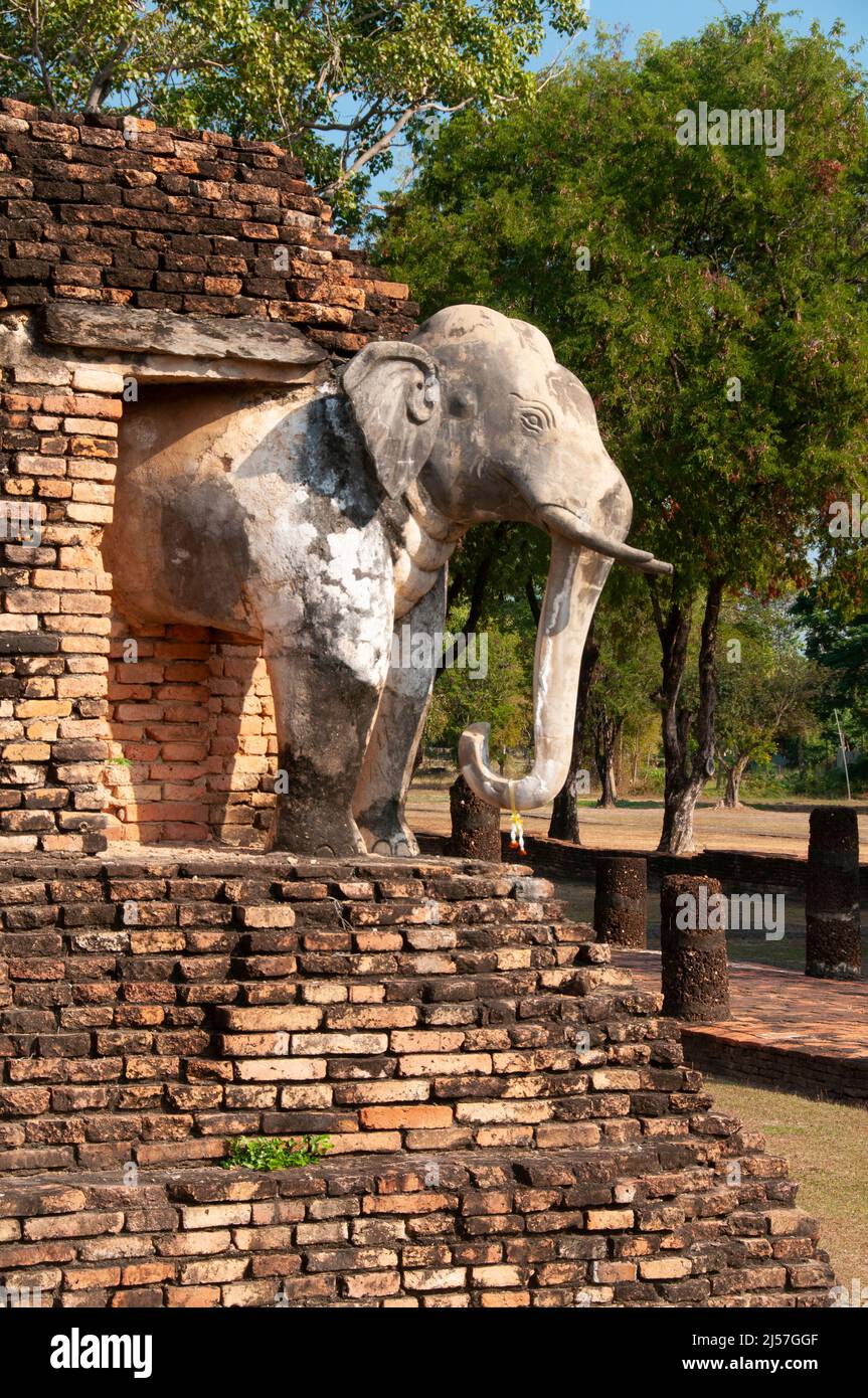 Thailand: Elefant schmückt die Ecke des Hauptchedi im Wat Chang Lom, Sukhothai Historical Park, Old Sukhothai. Sukhothai, was wörtlich „Morgenröte des Glücks“ bedeutet, war die Hauptstadt des Königreichs Sukhothai und wurde 1238 gegründet. Es war die Hauptstadt des thailändischen Reiches für etwa 140 Jahre. Stockfoto