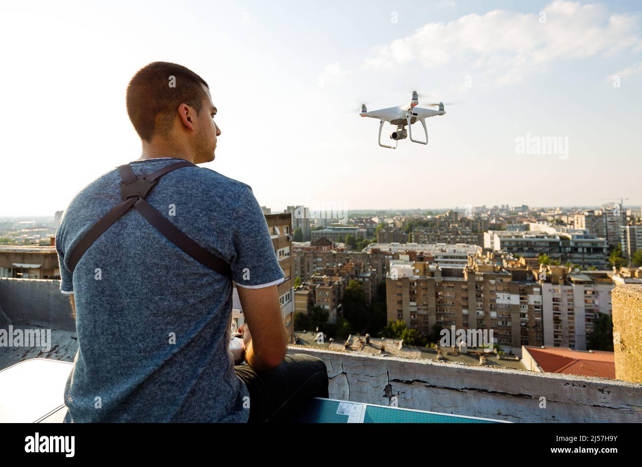 Mann Betrieb einer Drohne mit Fernbedienung auf der Dachterrasse Stockfoto