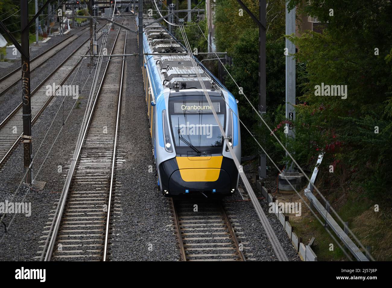 Cranbourne Bound Metro fährt HCMT, mit Wassertropfen auf dem Fenster, von einer Position über der Eisenbahnlinie aus gesehen, während es durch das Innere von Melbourne fährt Stockfoto