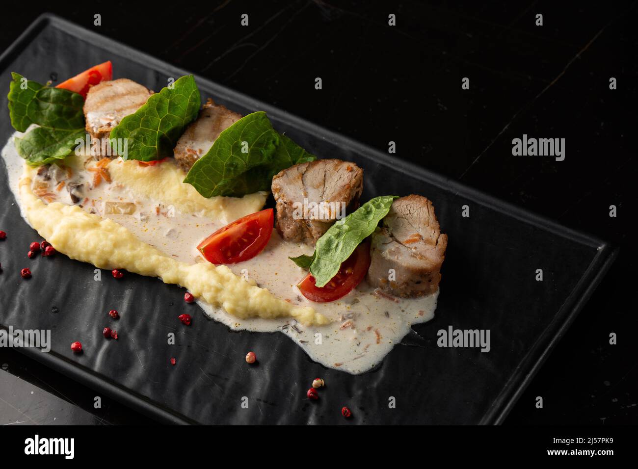Gebackenes Fleisch und Kartoffelpüree als Beilage auf weißem Teller ...