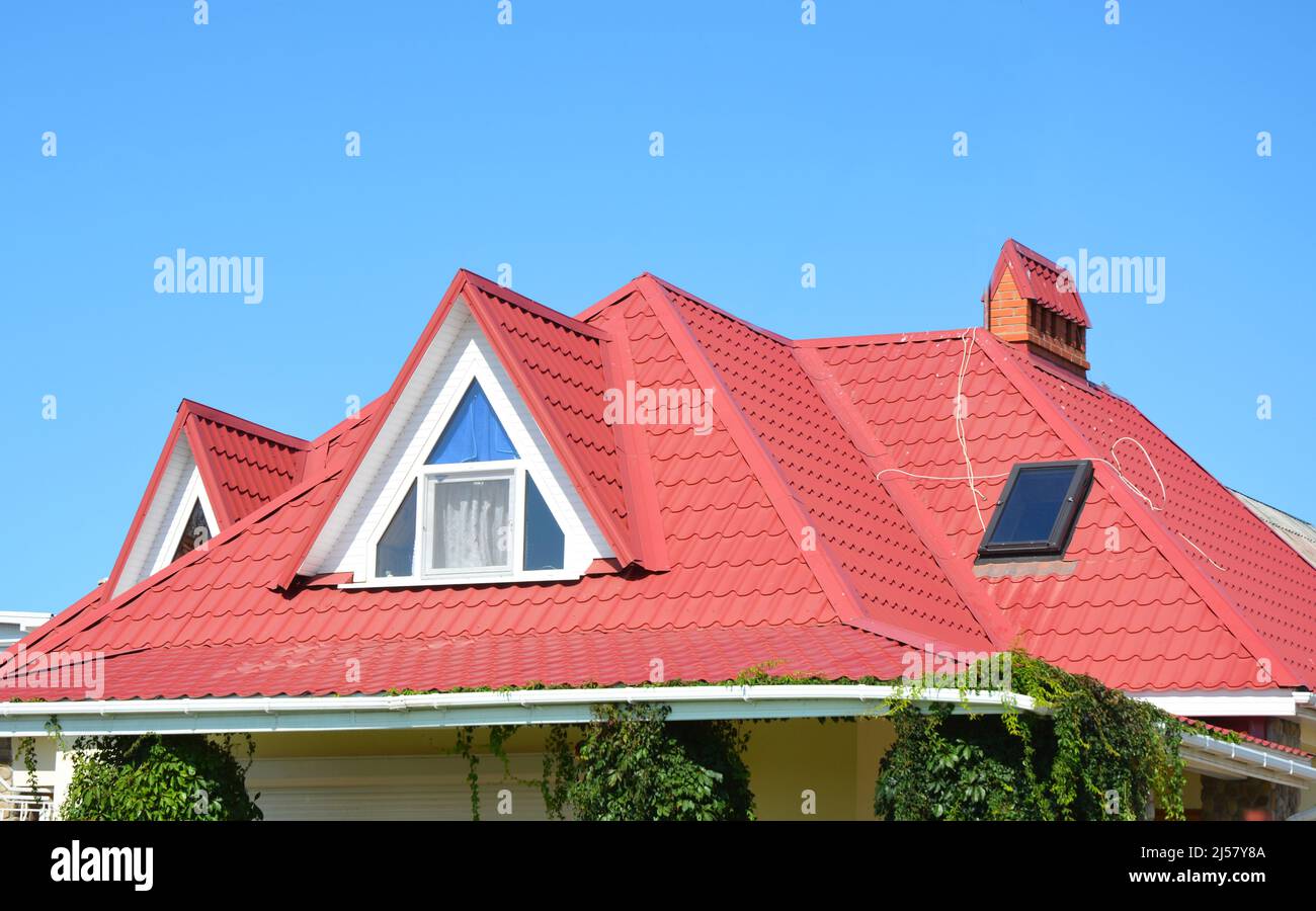 Tal- und Giebel-Dachkonstruktion mit Dachfenstern, Regenrinne, Abdichtung. Dachrinnensystem, Dachfenster auf Dachbodenhaus Metallfliesen Stockfoto