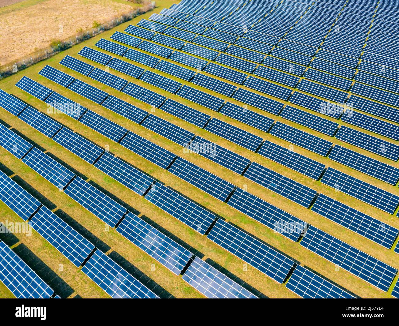 Luftaufnahme eines Solarparks mit vielen Photovoltaikmodulen für die Energiewende aus Drohnenperspektive in ländlicher Umgebung Stockfoto