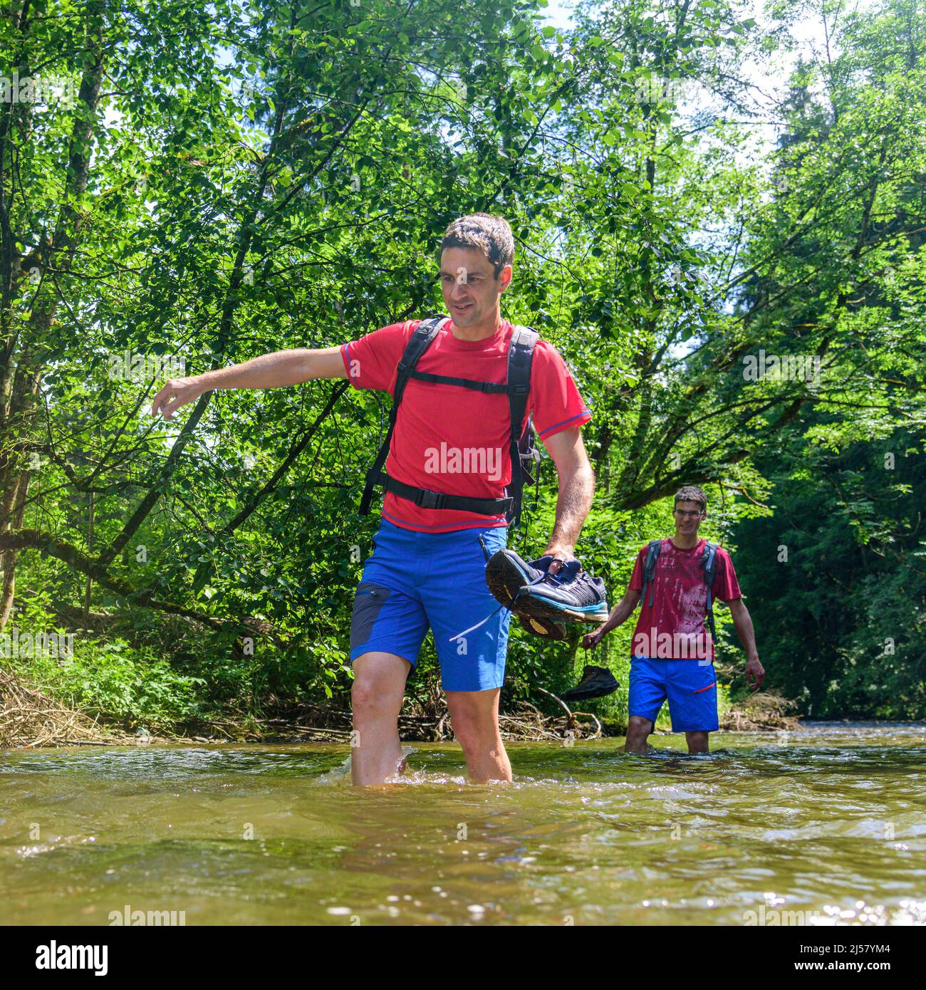 Eine Gruppe von Menschen Waten in einem Flussbett an einem heißen Sommertag im Allgäu Stockfoto