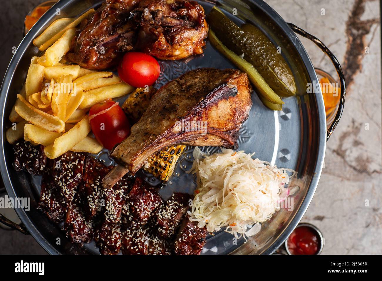 Köstliche Fleischplatte, Schweinerippchen, gegrilltes Hähnchen, Wurst, Rindfleisch, Gegrillte Kartoffeln. Mit Sauce verschiedene leckere gegrillte Fleisch mit Gemüse und Kräuter Stockfoto