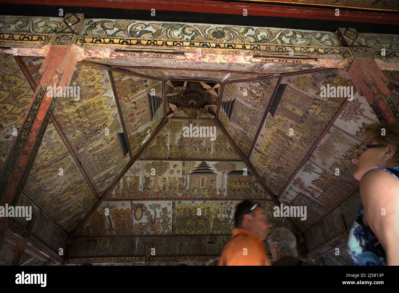 Touristen im Kertha Gosa, einem berühmten Pavillon, dessen Decke alte, traditionelle balinesische Kamasan-Malerei zeigt, in Klungkung, Bali, Indonesien. Stockfoto