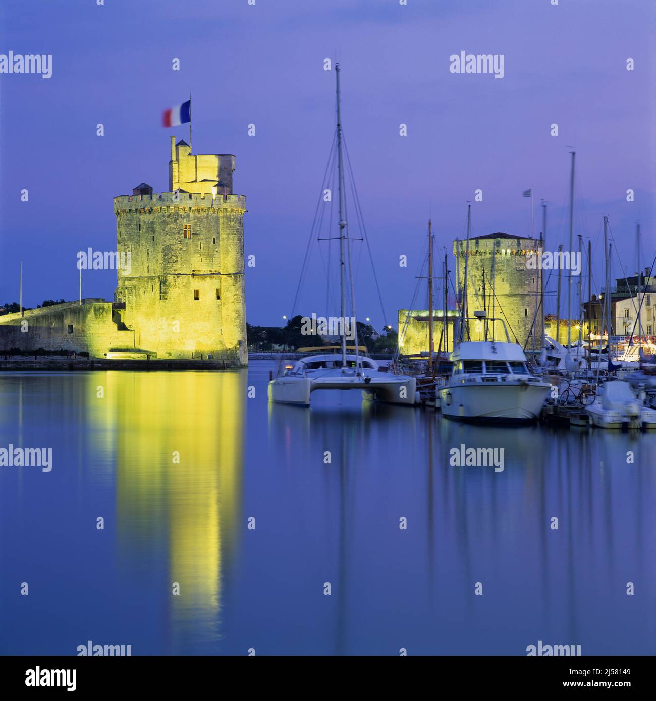 Der alte Hafen mit der Tour de la Chaine und den St. Nicolas Türmen, die in der Abenddämmerung erleuchtet werden, La Rochelle, Nouvelle Aquitaine, Atlantikküste, Frankreich, Europa Stockfoto
