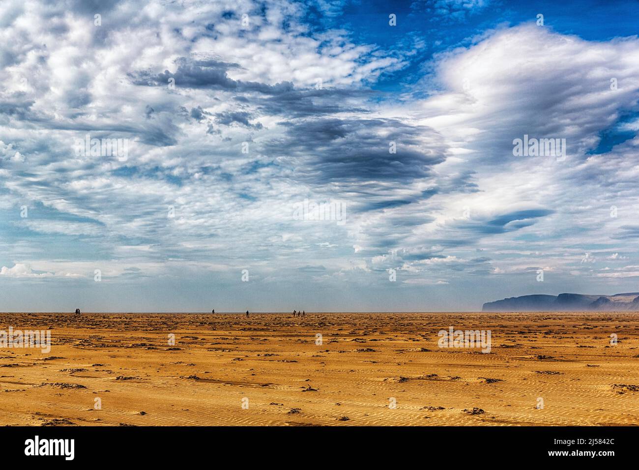 Abgelegener Sandstrand, windgeschaffene Strukturen, Klippen und Wanderer am Horizont, Rauoisandur, Raudisandur im Sommer, gutes Wetter, in der Nähe Stockfoto