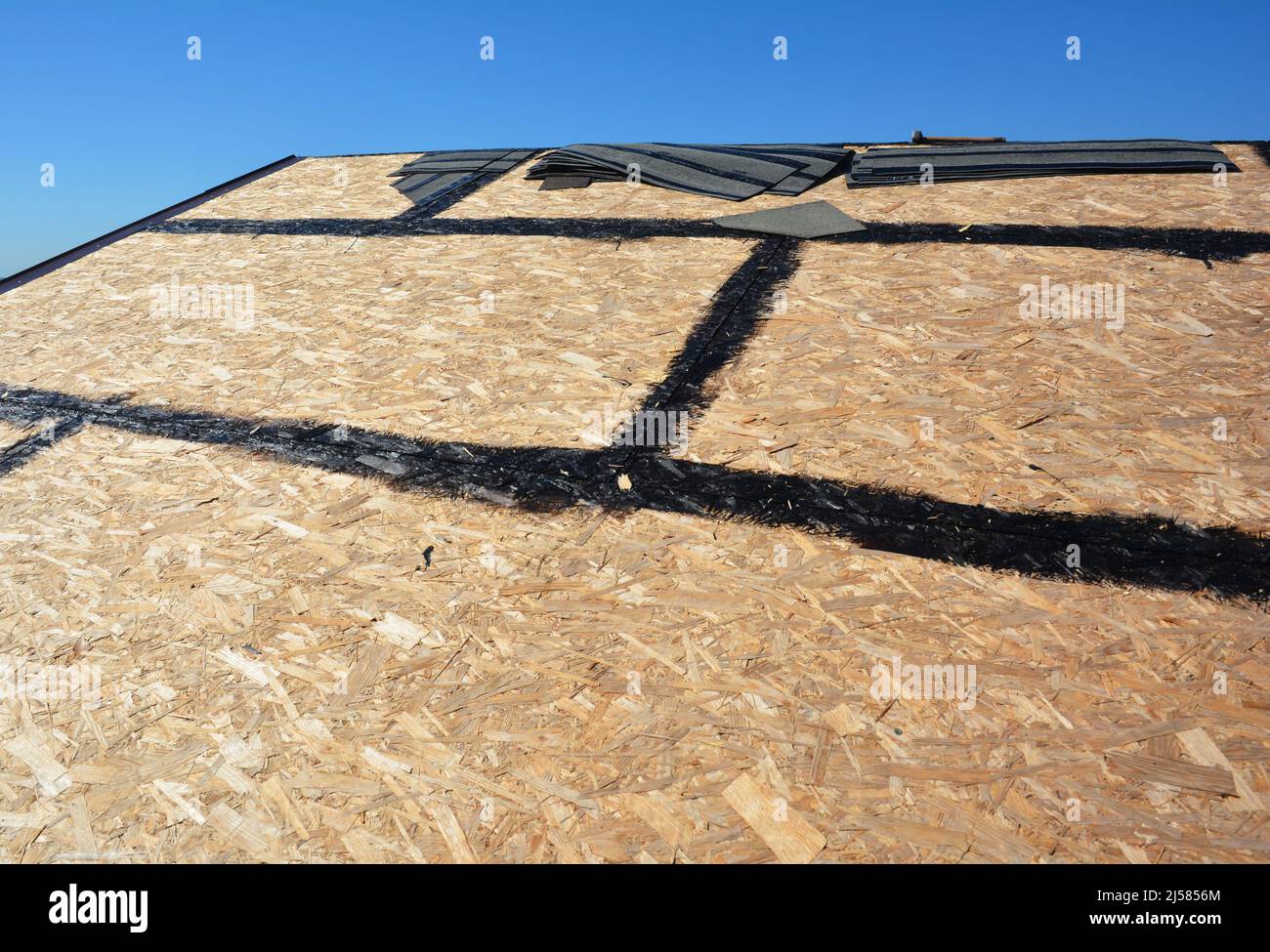 Dachvorbereitung Asphaltschindeln Installation auf Hausbau Holzdach mit  Bitumenspray. Dachkonstruktion. Bitumendach montieren sh Stockfotografie -  Alamy
