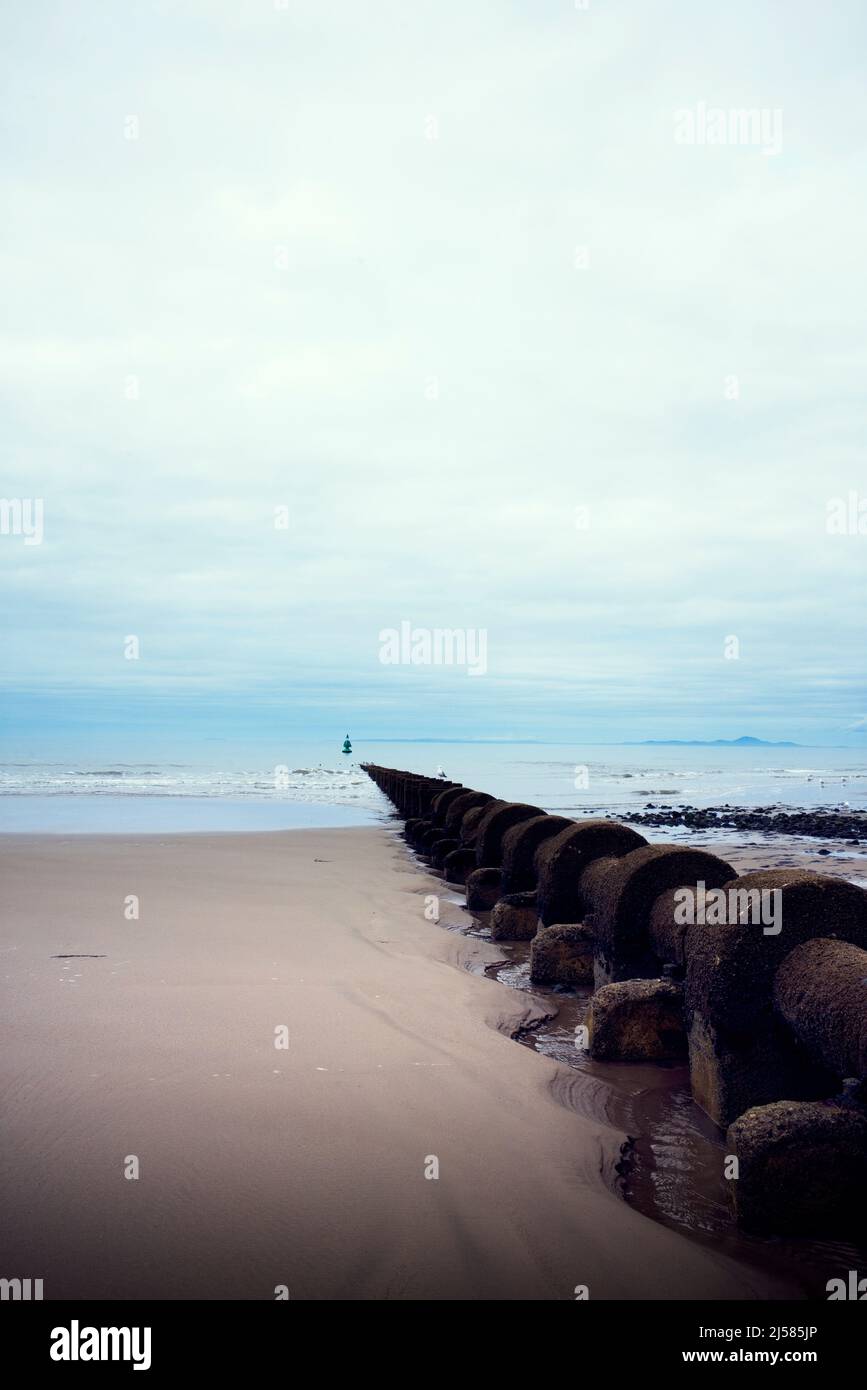 Eine lange Abwasserleitung, die in Barmouth, Nordwales, ins Meer hinausgeht Stockfoto