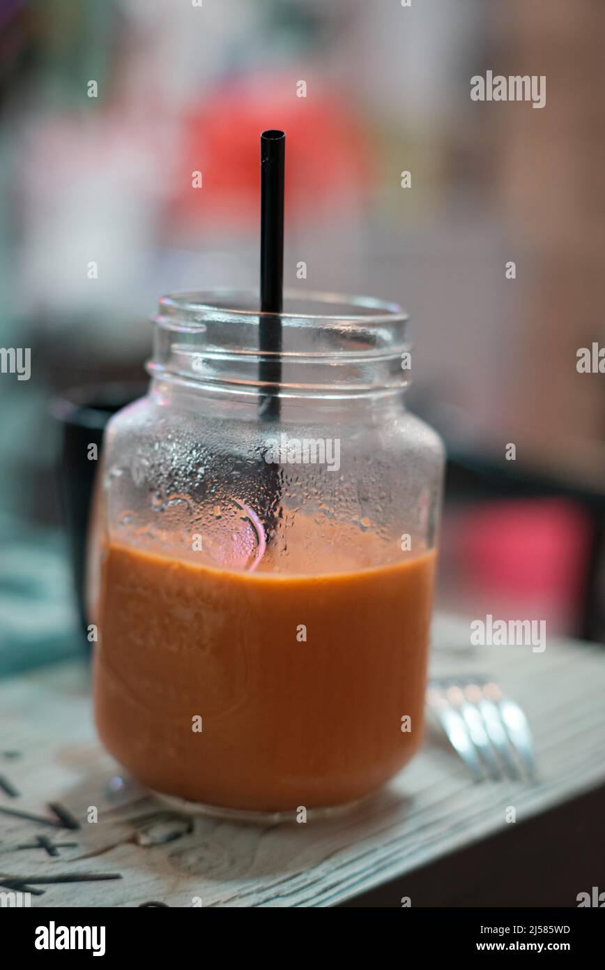 Thailändischer Milchtee im Glas in einem thailändischen Restaurant Stockfoto