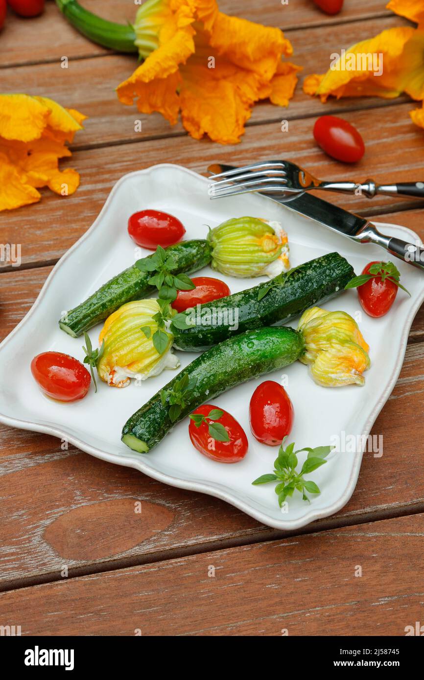 Süddeutsche Küche, gefüllte Zucchini-Blumen auf Teller sautiert, Frischkäse, Cocktailtomaten, Kirschtomaten, vegetarisch, Gesunde Küche Stockfoto