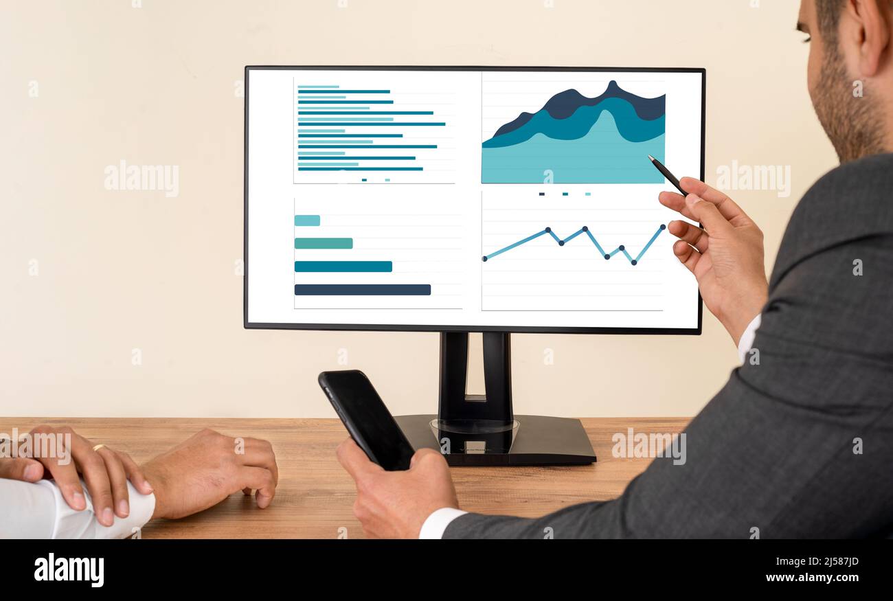 Nahaufnahme eines Geschäftsmannes mit Laptop und Computer. Konzept von Datendiagrammstatistiken und Infografiken zu Einkommen und Einnahmen mit Screen-Mockup. Stockfoto