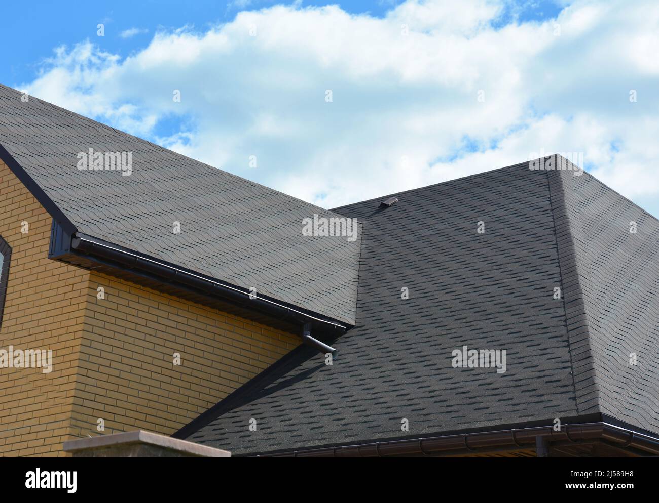 Wasserabdichtung Dachproblematik mit Asphaltschindeln und Regenrinne. Asphaltschindeln Dachkonstruktion. Stockfoto